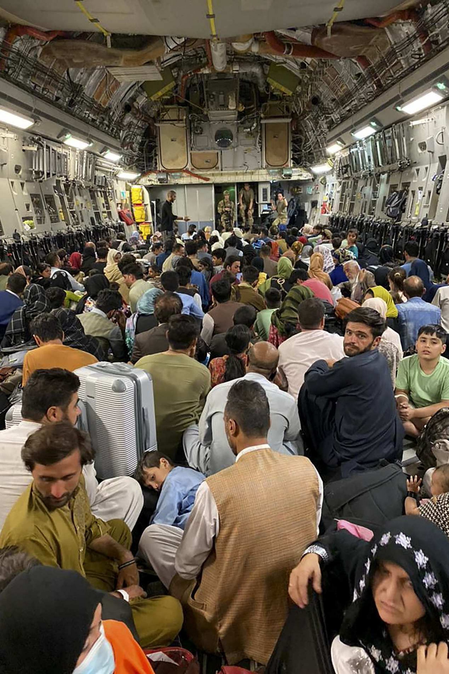 Afegãos dentro de um avião militar norte-americano para deixar o país, no aeroporto de Cabul