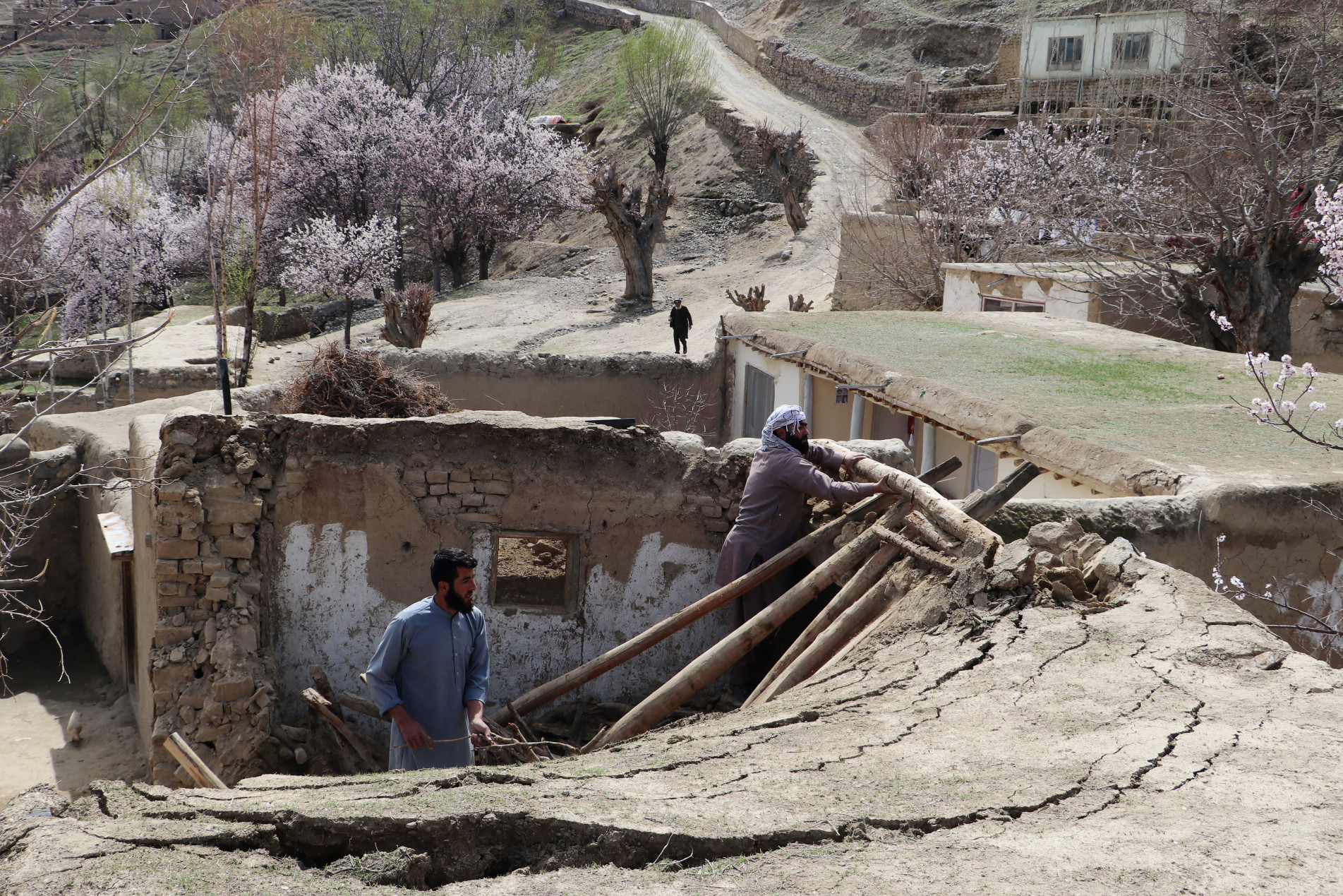  Residents remove debris from the rooftop of damaged a house at Sooch village in Jurm district of Badakhshan Province on March 22, 2023, following an overnight earthquake. - At least 13 people were killed in Afghanistan and Pakistan by a strong earthquake felt across thousands of kilometres, but the region appeared on March 22 to have dodged the mass casualties usually associated with a tremor of such scale. (Photo by OMER ABRAR / AFP)