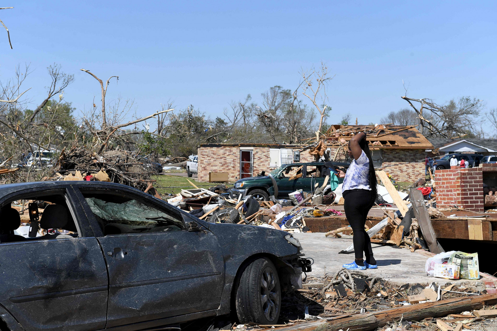 Moradores observam os escombros após a passagem do tornado, no Mississipi