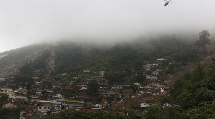 Bombeiros, moradores e voluntários trabalham no local do deslizamento no Morro da Oficina, após a chuva que castigou Petrópolis, na região serrana fluminense