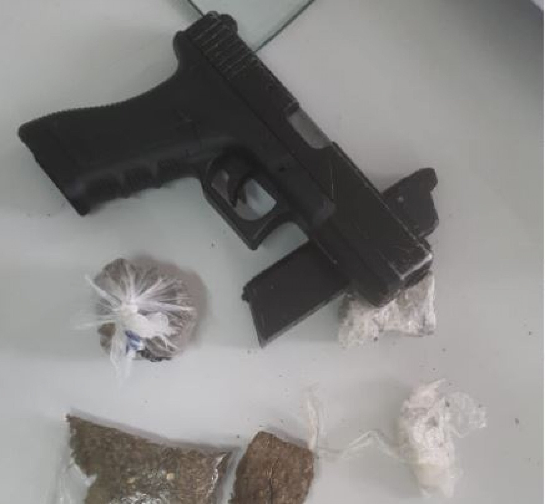 Agentes encontraram porções de maconha já embaladas e prontas para serem comercializadas, além de um simulacro de pistola