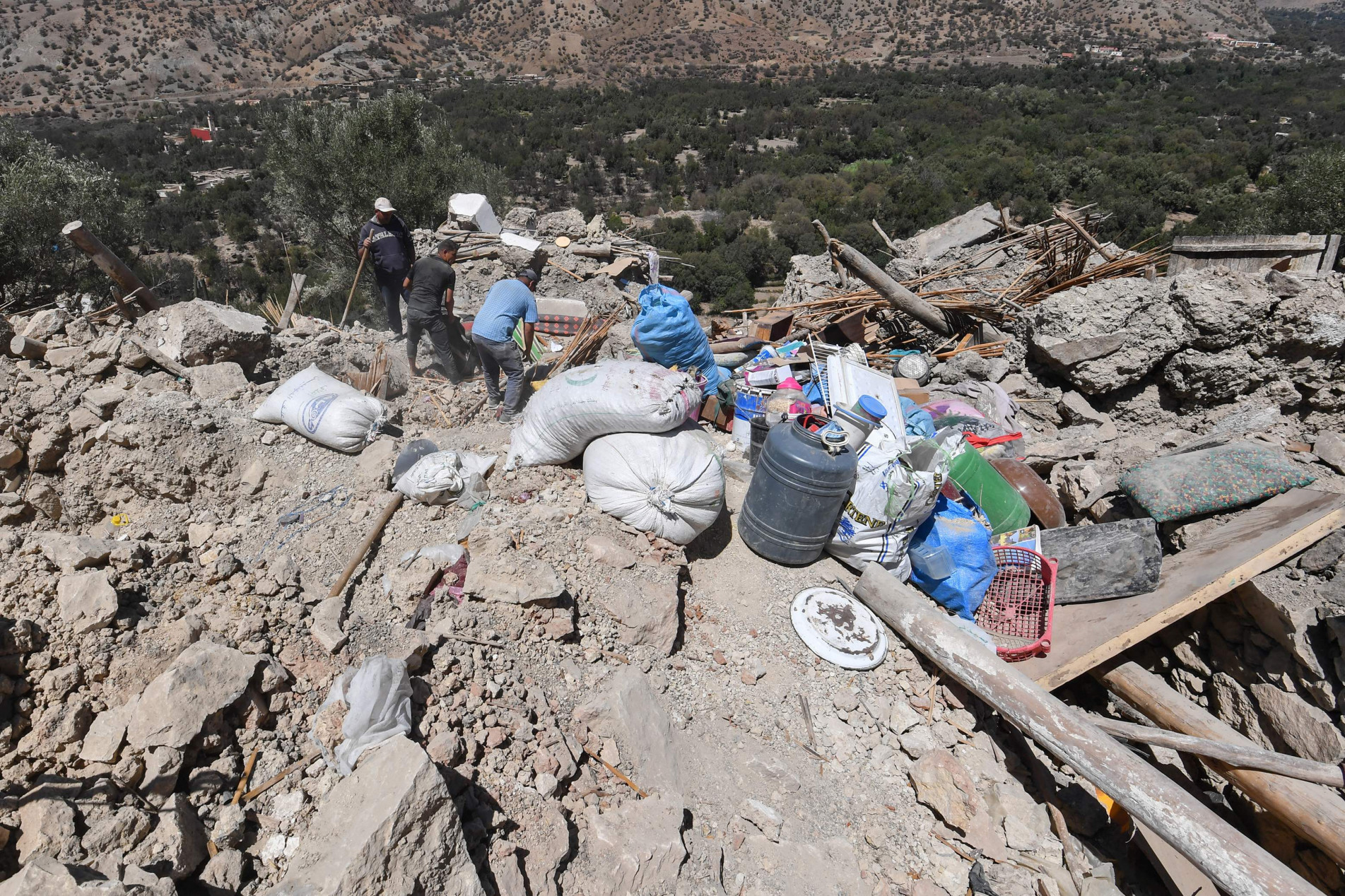 Moradores resgatam pertences dos escombros da aldeia de Imoulas, na província de Taroudant, uma das mais devastadas no Marrocos