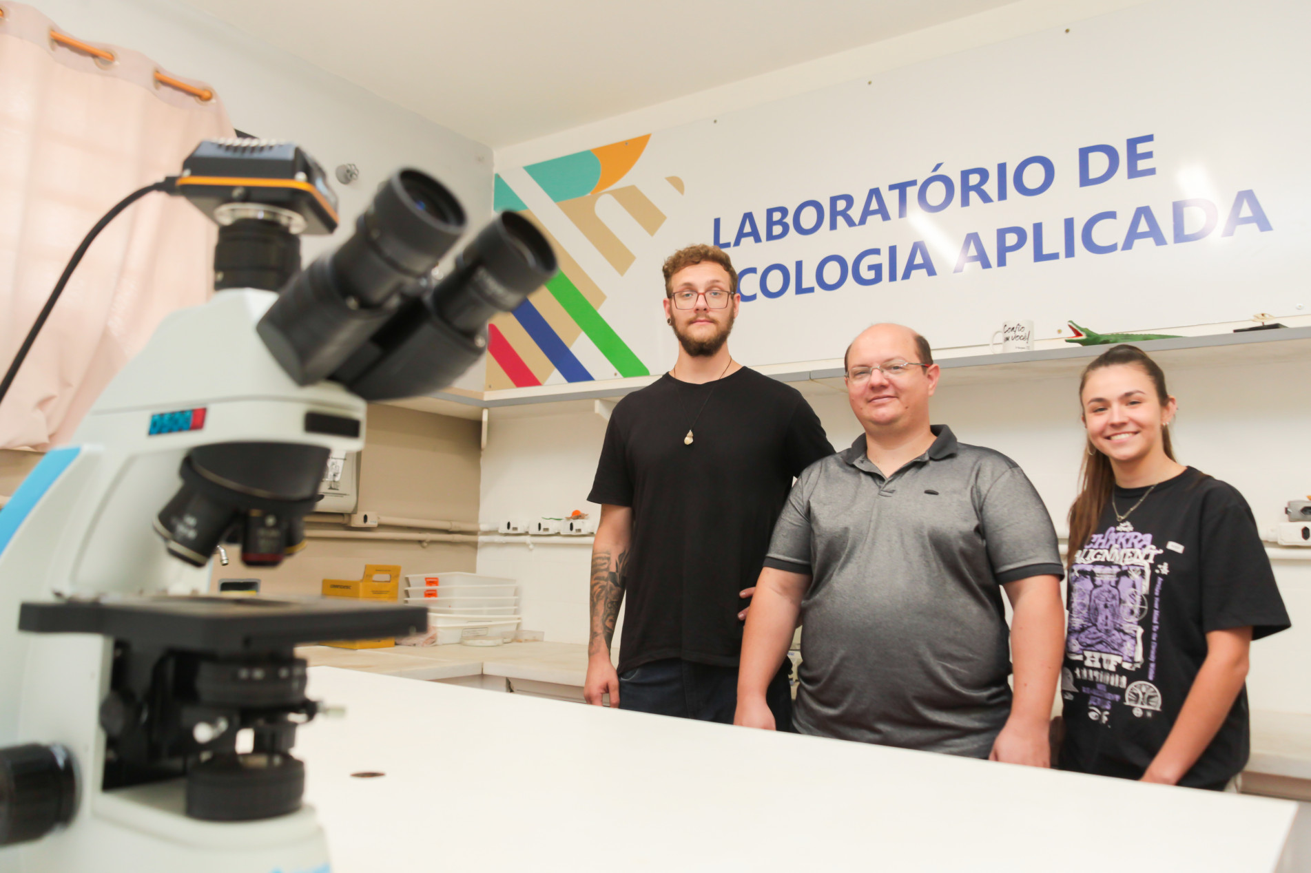 Prof. Thiago (centro) ao lado dos estudantes Guilherme e Bárbara, que assinam a carta
