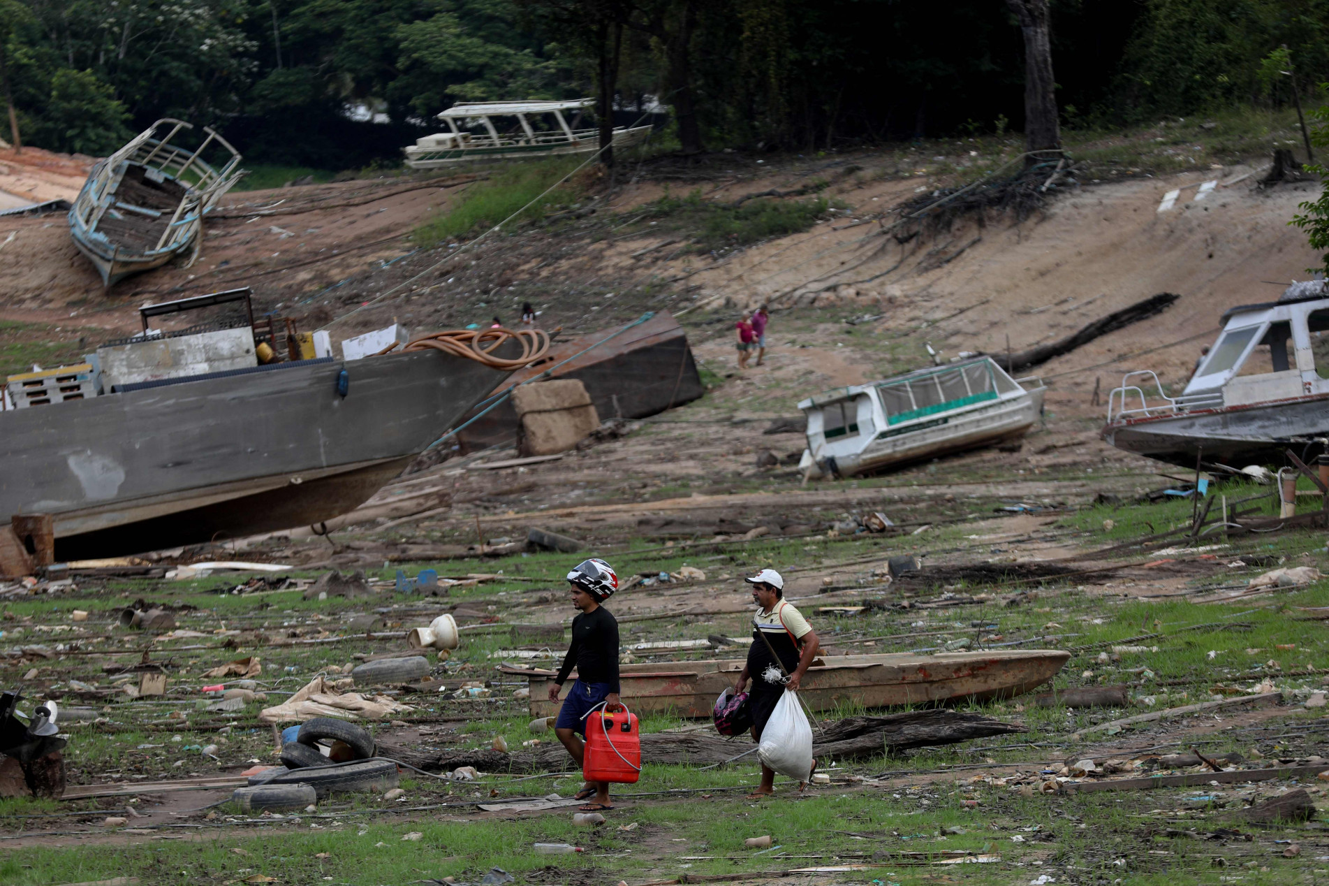 Em Manaus, pessoas caminham pelo leito seco do Rio Negro