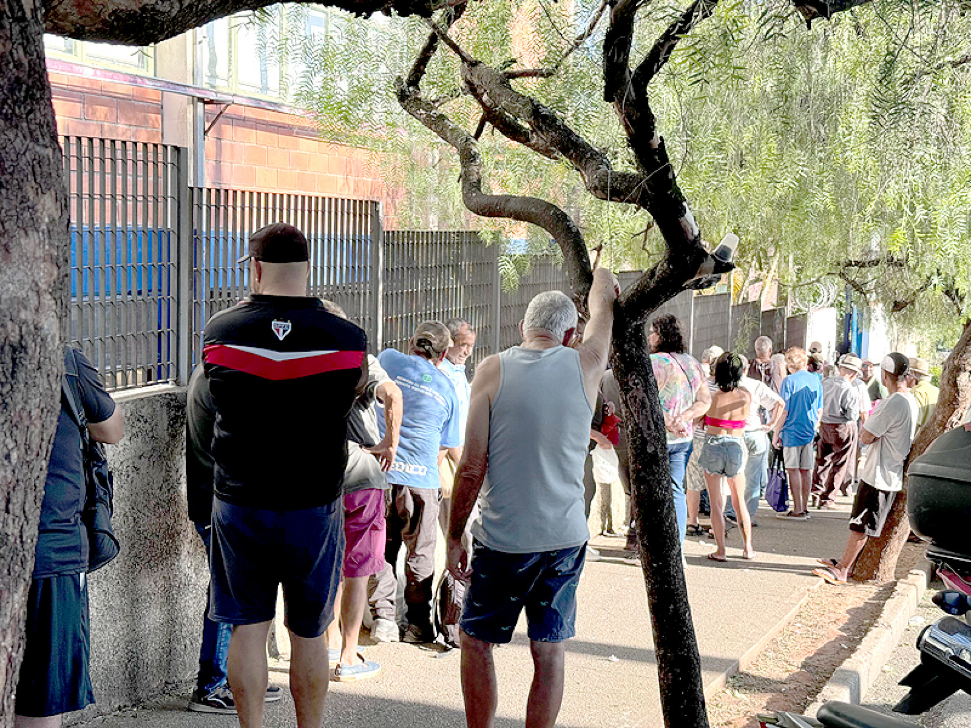 Pessoas costumam esperar até uma hora para poder pegar refeições no Bom Prato
